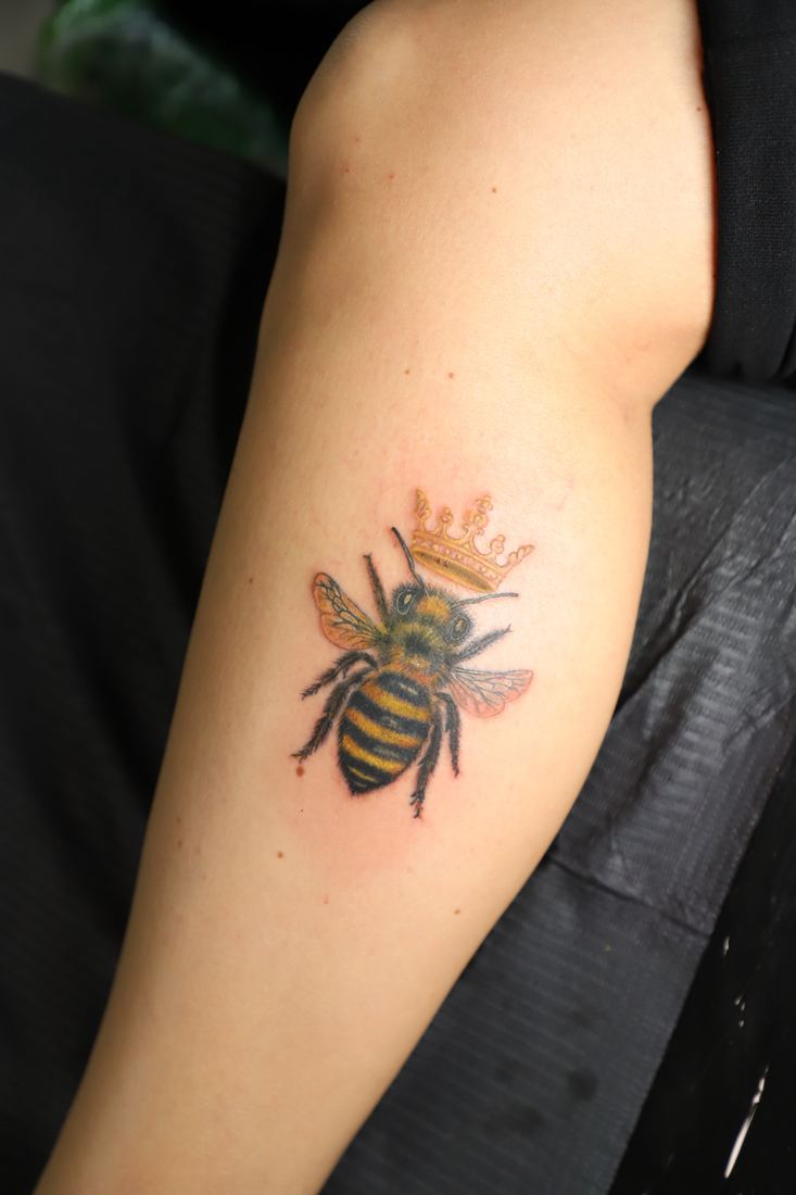Bee with a crown on the forearm