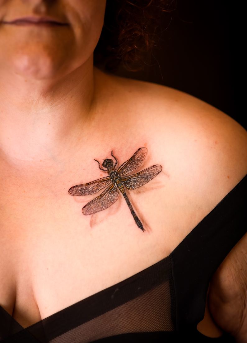 Fine line dragonfly on the collarbone