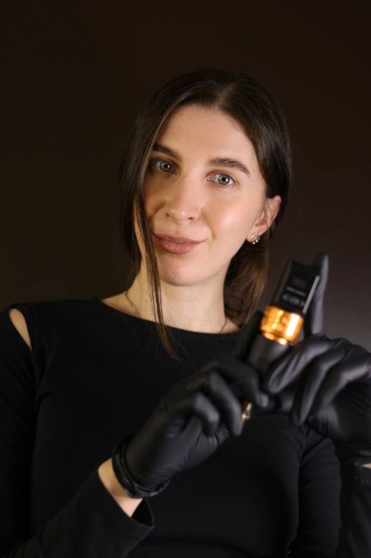 Ladygina, tattoo artist, holding a tattoo machine